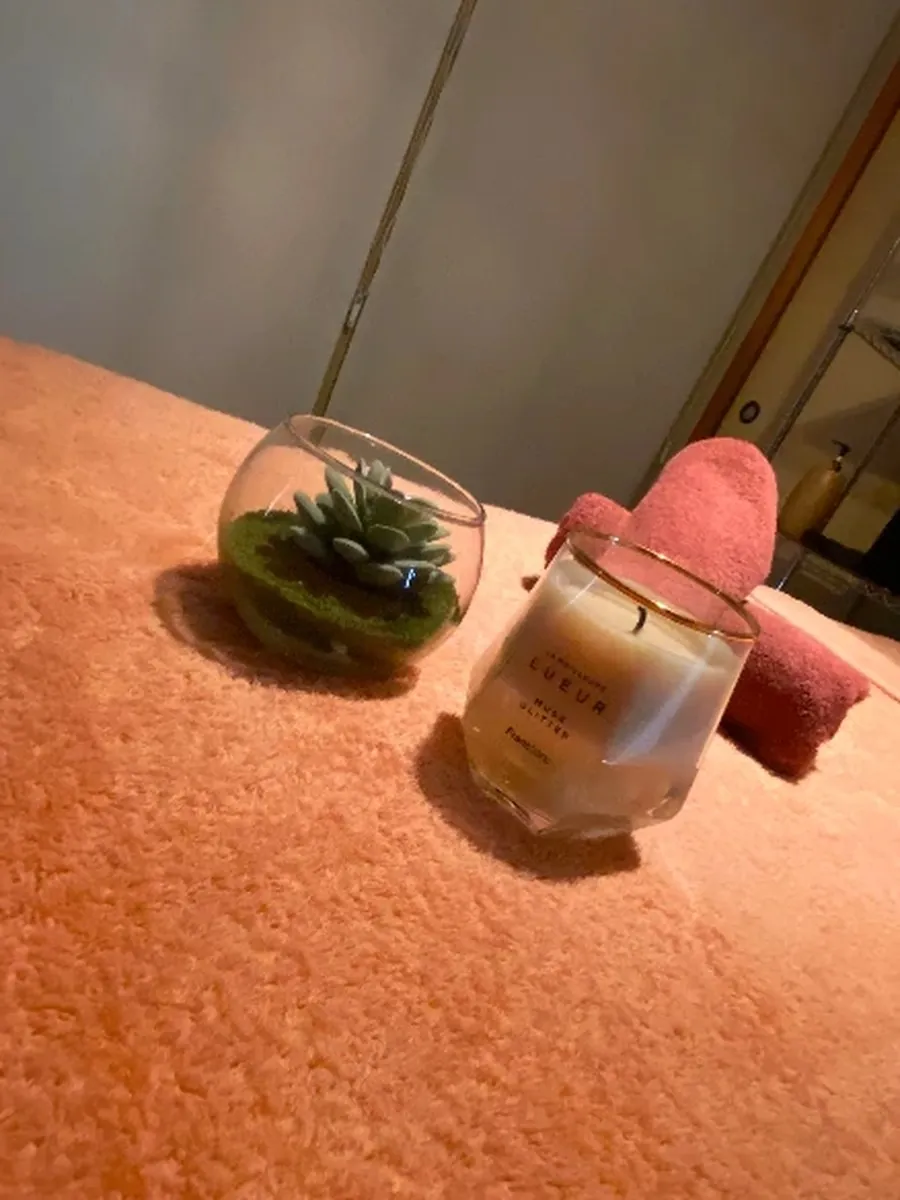 Luciaの施術ベッド。観葉植物とキャンドルを置いた落ち着いた空間